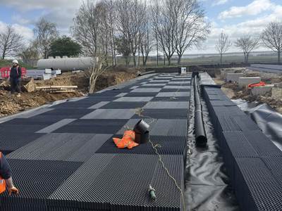 Rows of geocellular attenuation crates on membrane with pipework connections, ready for wrapping